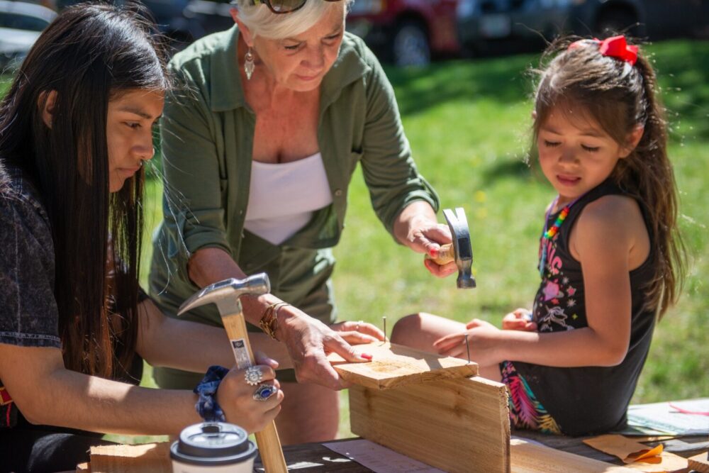 Family building a bird house at event
